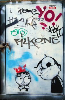 Rusty metal surface covered with stencil graffiti and tags. Urban street art.