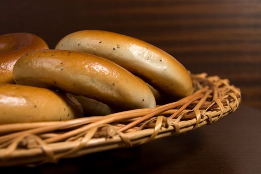 Appetizing bagels on wicker plate at the table