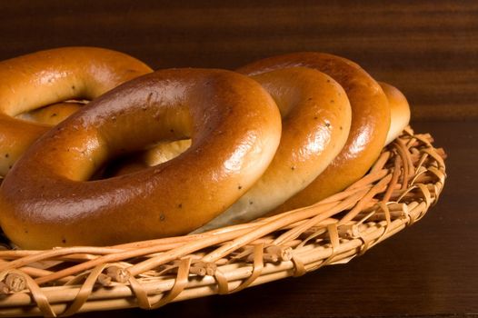 Appetizing bagels on wicker plate at the table