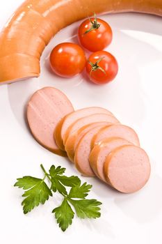 Cut boiled sausage with parsley and tomato