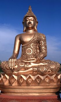 statue of a golden buddha against a blue sky
