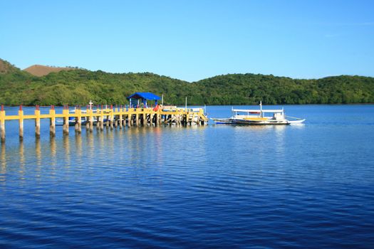 a pier from a resort leading to a boat
