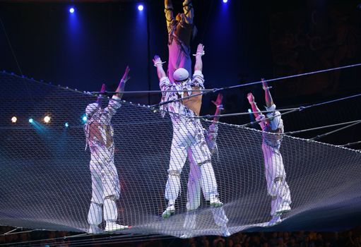 Two air acrobats carry out dangerous exercise under a dome of a circus