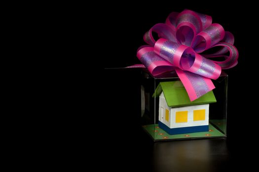 Small house in gift packing on a black background