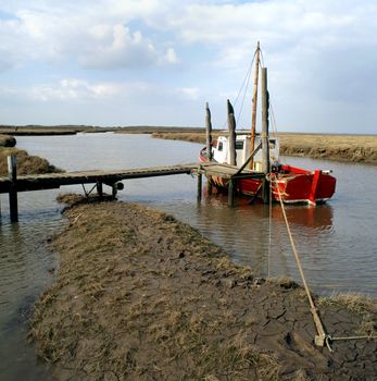 A boat tied up on the fenland of East Anglia