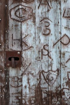 Vertical image on an old barn door covered in western brands