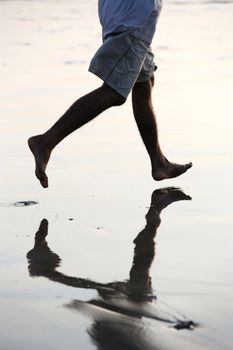 Feet of a running man on beach