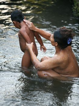 Mother bathes the child in the river. Indonesia. Bali