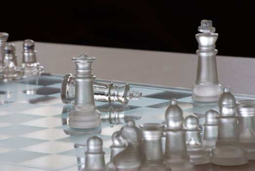 Horizontal image of a glass chess set.