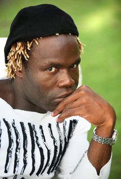 Portrait of young sad African descent man in white t-shirt on green background. Indonesia