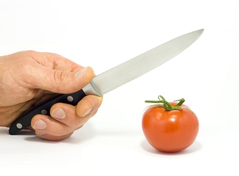A hand with knife and tomato on white background