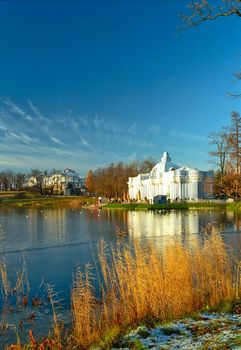 Classical buildings near the bank of iced lake in sunny day