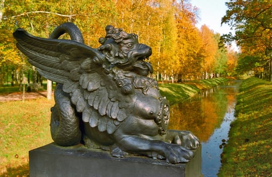 Sculpture of the Dragon on foreground of the autumn landscape