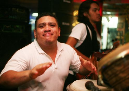 Smiling musician at an alive concert in a night club "La vida loka". Bali. Indonesia