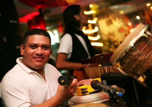 Smiling musician at an alive concert in a night club "La vida loka". Bali. Indonesia