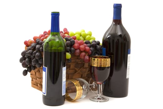 Red wine and three different kinds of grapes in a basket