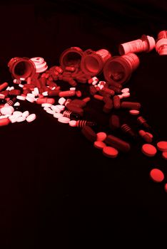 Drugs, prescriptions medicines, pills, and bottles pouring out onto black background