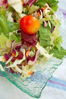 Glass bowl with fresh mixed salad. Raw food background.