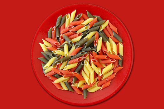 Red plate with three flavors of penne pasta. Italian food background.