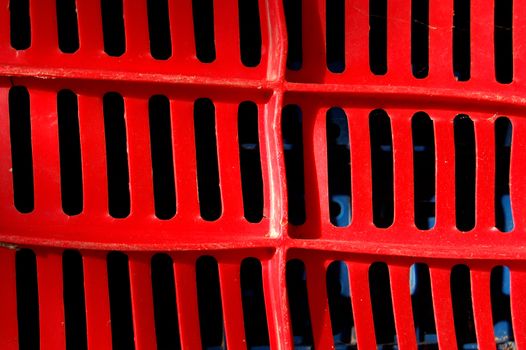 Red plastic crate. Fruit packing container detail.