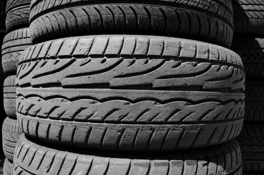 Pile of used car tires background. Black and white.