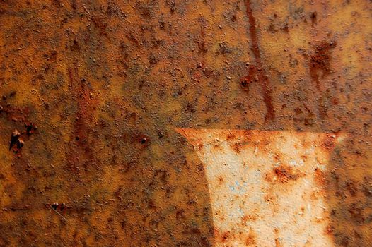 Type stencil detail on rusted metal surface. Abstract background texture.
