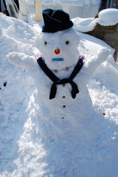 A snowman with hat and scarf on a cold winter day.