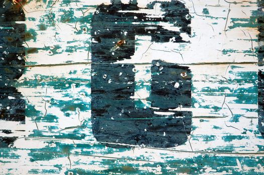 Type stencil detail on weathered and rusty metal surface. Background texture.