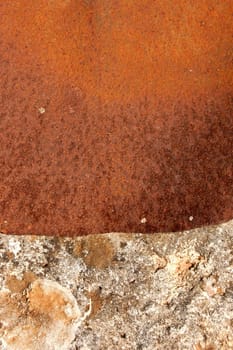 Rusty sheet of metal covering the opening of an old stone well.