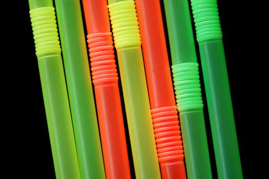 Drinking straws isolated on black background. Abstract pattern.