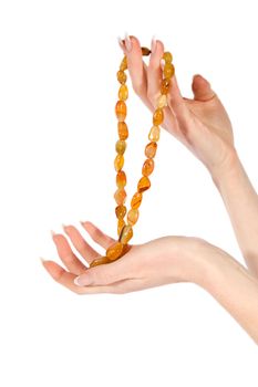 Woman hands holding amber necklace over white
