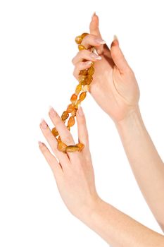 Woman hands holding amber necklace on white