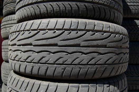 Pile of used rubber car tires. Abstract background.