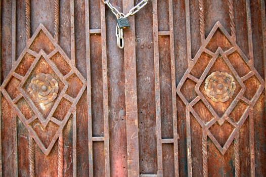 Rusty metal door with floral pattern. Abstract background texture.