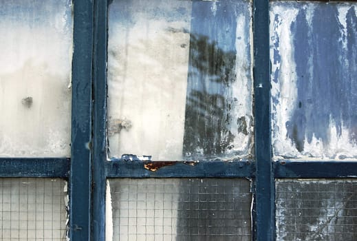 Weathered industrial window detail with tree reflections. Abstract background.