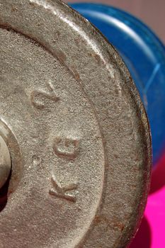 Metal dumbbell hand weight detail. Sports equipment background.