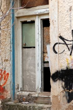 Abandoned house boarded up window detail and weathered wall.