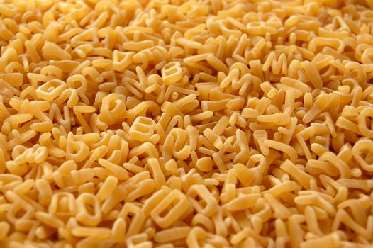 Alphabet soup letters pasta. Italian kids food background.
