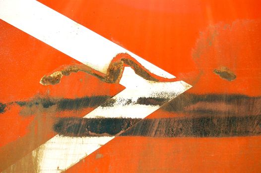 Arrow stencil on industrial metal surface. Scratched paint and rust macro background.