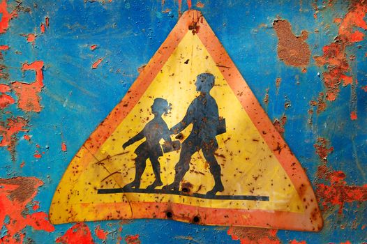 Rusty traffic control warning sign for school children. Speed restriction.