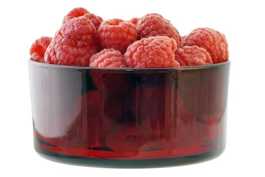 Sweet and delicious raspberries in a vintage red colored glass bowl isolated on white background
