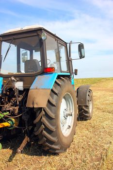 Tractor in a field, agricultural scene in summer