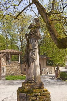 Ancient statue of mother and child in a park