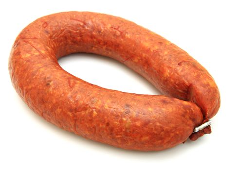 Tasty sausage is curtailed by a ring lies on a white background