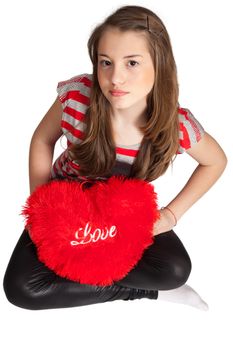 Beautiful Girl Sitting With Heart Shaped Red Pillow isolated on white background.