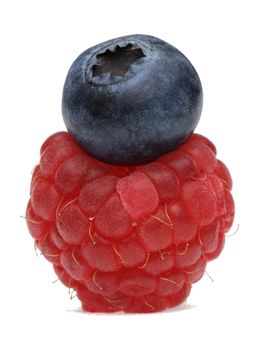 Image of a blueberry over a raspberry photographed in a studio against a white background.