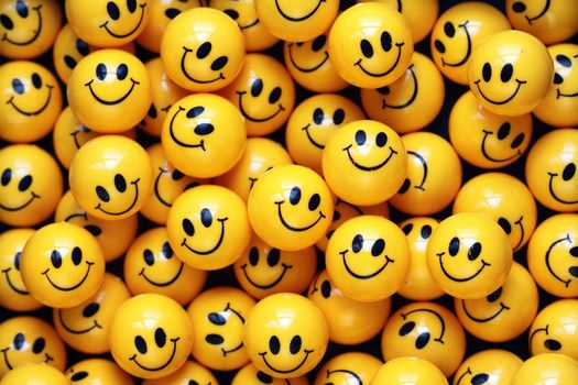 heap of yellow balls with smiley faces