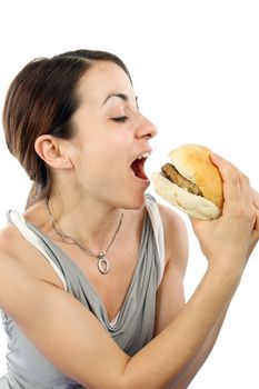 Young woman eating hamburger over white background 