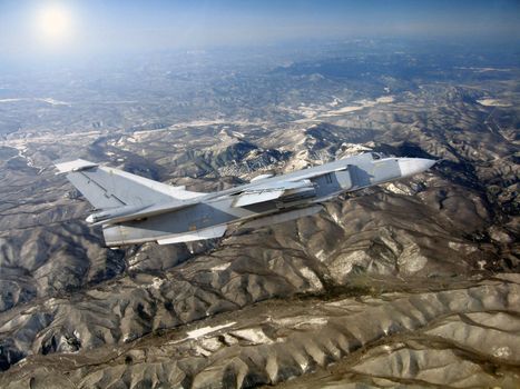 Military jet bomber Su-24 against mountains