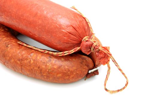 Tasty sausage is curtailed by a ring lies on a white background
